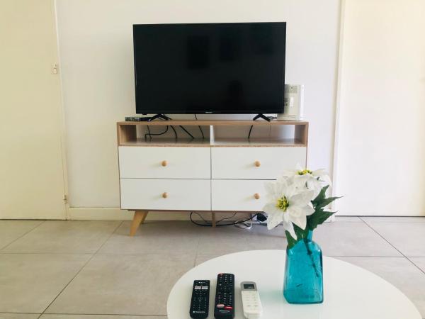 sala de estar con TV y jarrón con flores en Coqueto depto. en pleno Cañitas - Campo de Polo en Buenos Aires