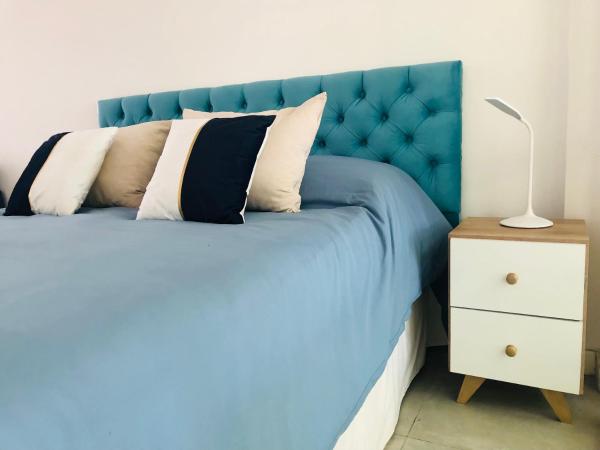 1 cama azul con cabecero azul y mesita de noche en Coqueto depto. en pleno Cañitas - Campo de Polo en Buenos Aires