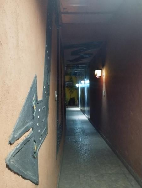 un pasillo con una señal de flecha en la pared en Departamentos Temporarios Salta en Salta