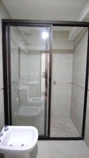 y baño con ducha acristalada y lavamanos. en Azucena Apart II en Salta