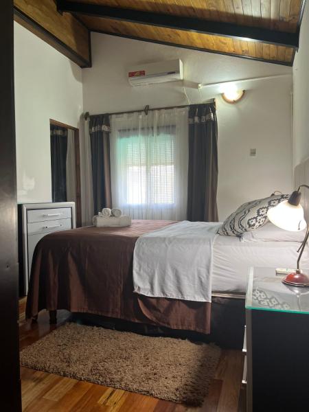 Un dormitorio con una cama grande y una ventana en Departamento Porá en Puerto Iguazú