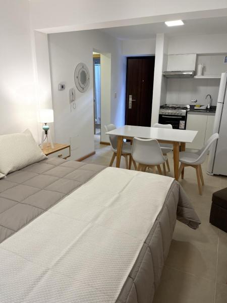 1 dormitorio con cama, mesa y cocina en Vista Norte 3 - Andarlibre en San Martín de los Andes