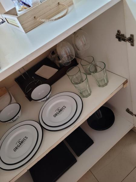 un armario con platos y vasos en un estante en Departamento excelente ubicación en San Juan