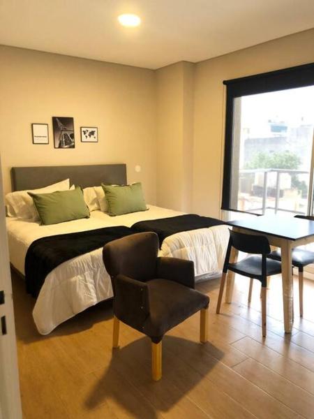 1 dormitorio con 1 cama, mesa y sillas en 6A Monoambiente capital, amplio, luminoso y acogedor en Buenos Aires