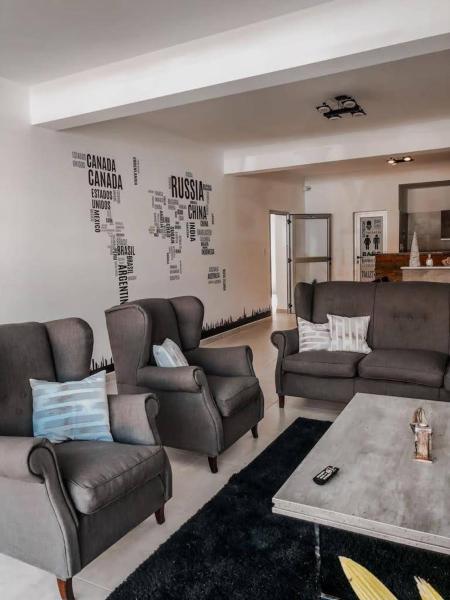 sala de estar con sofás, sofá y mesa en Apart Hotel Verona en Puerto Madryn