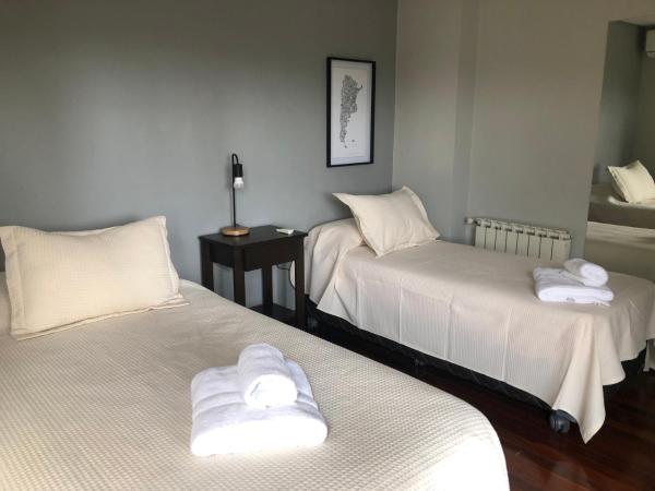 Habitación con 2 camas y toallas blancas. en La Infinita en Mendoza