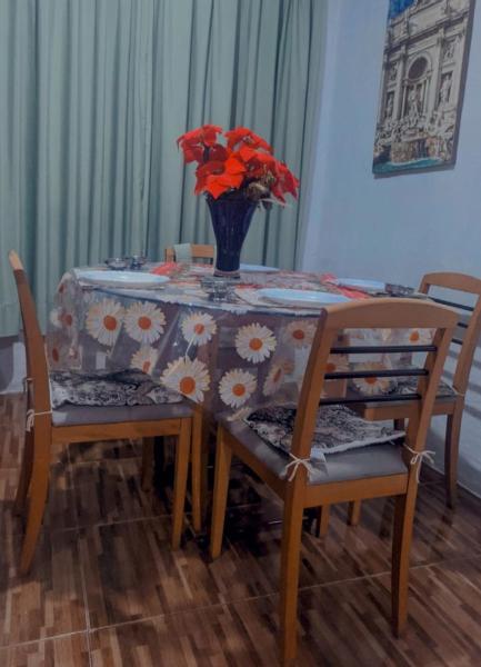 una mesa de comedor con un jarrón de flores. en villa foresti macedo gramado, en Gramado