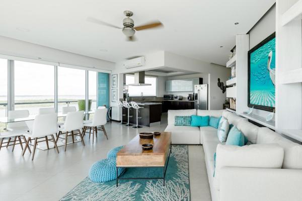 sala de estar con muebles blancos y detalles en azul en Espectacular Departamento de lujo frente al mar, en Cancún