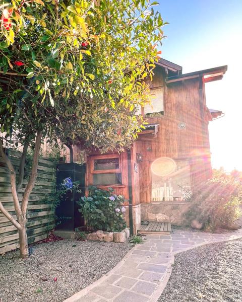 una casa de madera con un árbol delante en El Abedul Cabaña en La Cascada, SMA en San Martín de los Andes