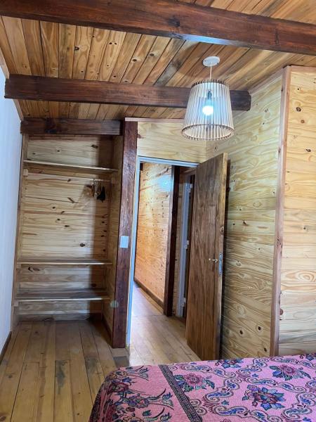 1 dormitorio con paredes de madera y techo con 1 cama en Tus cabañas en Las Grutas