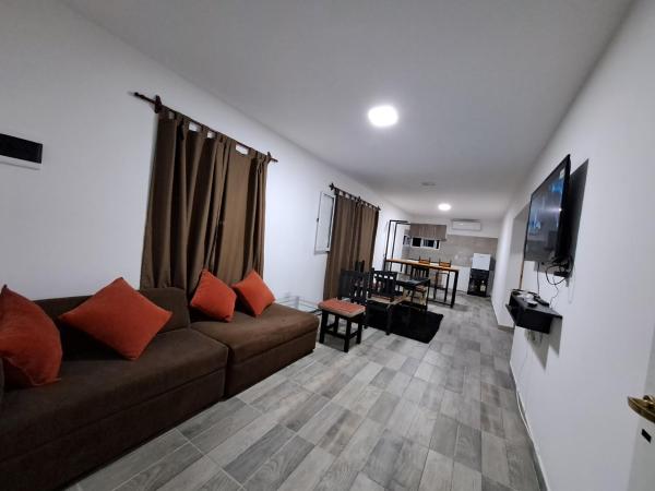 sala de estar con sofá y Tv LED en La Mora en Salta