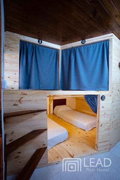 Cabaña con 2 literas y cortina azul en LEAD Pods Hostel en Salta