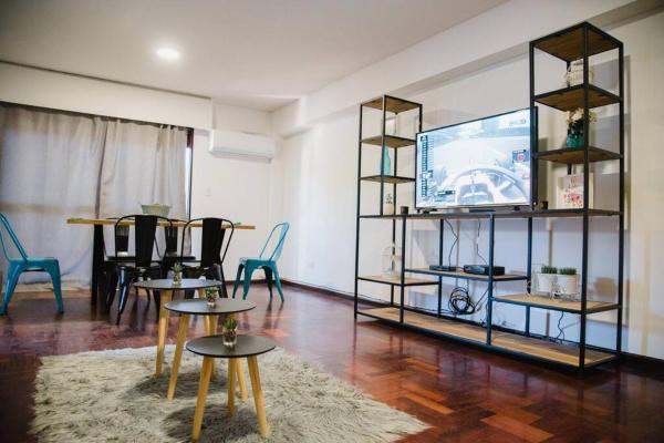 sala de estar con mesas y Tv LED en Avenida España Apartments. Pleno centro de Mendoza en Mendoza