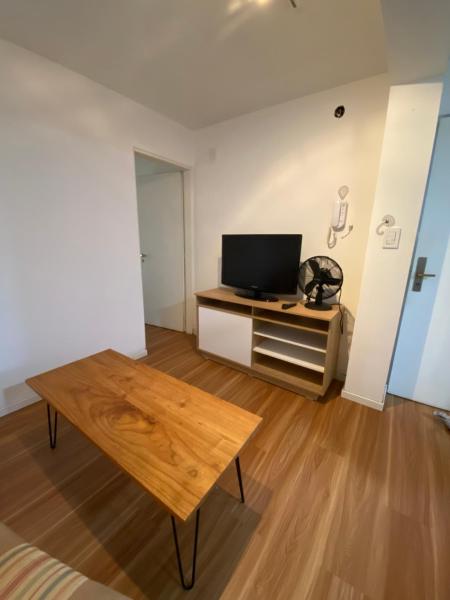 sala de estar con TV y mesa de madera en Departamento 1 dormitorio San Luis - Excelente Ubicación en San Luis