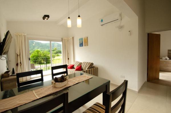 cocina y sala de estar con mesa y sillas en Los Cóndores Aparts. en Villa General Belgrano