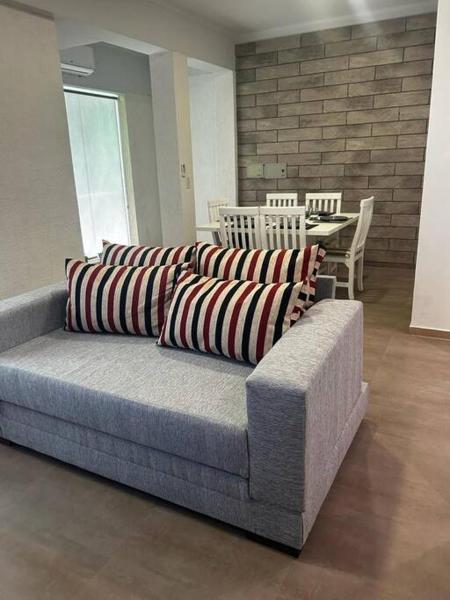 un sofá con almohadas en la sala de estar en Departamento zona céntrica MDZ en Mendoza