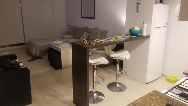 cocina con mesa y taburetes en una habitación en Natureza en Pinamar