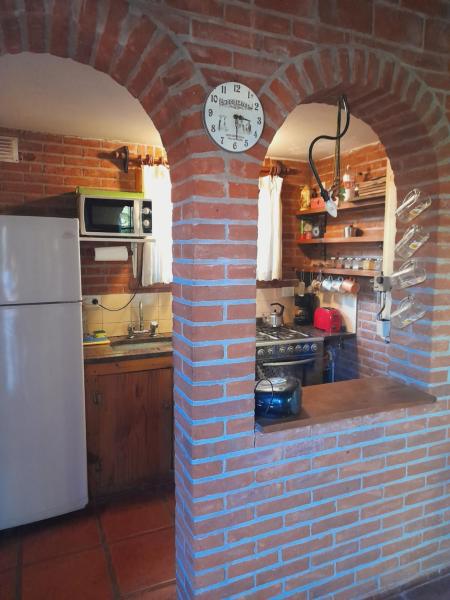 una pared de ladrillo en una cocina con refrigerador blanca en La Maga, Casa para Familias en Pinamar