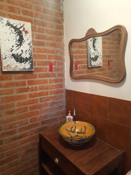 baño con espejo y un bol sobre una mesa en La Maga, Casa para Familias en Pinamar