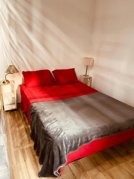 1 dormitorio con cama roja y almohadas rojas en Departamento cerca del Obelisco en casco histórico en Buenos Aires