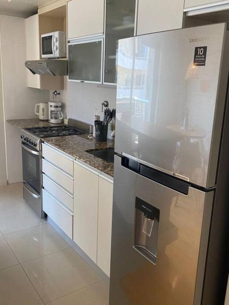 una cocina con refrigerador y electrodomésticos de acero inoxidable en Cozy 1-bedroom apartment in the heart of V.Urquiza en Buenos Aires