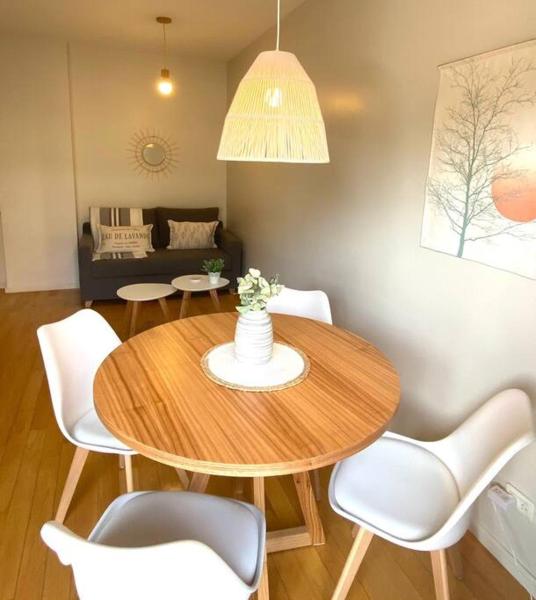 sala de estar con mesa de madera y sillas blancas en Cozy 1-bedroom apartment in the heart of V.Urquiza en Buenos Aires