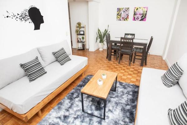 una sala de estar con 2 sofás blancos y una mesa. en Arevalo - 1 Bd in Las Cañitas en Buenos Aires