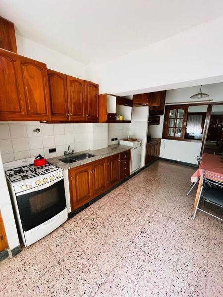 cocina con armarios de madera y horno con fogones en Casa Itu. en Gualeguaychú