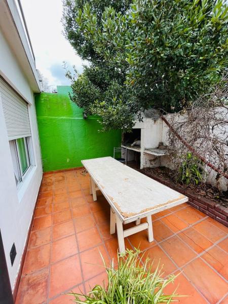 un banco sentado en un patio junto a una pared verde en Casa Itu. en Gualeguaychú