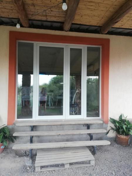 un porche cerrado de una casa con ventanas en Aguara House, Pedemonte - Mendoza en Mendoza