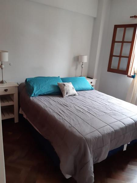 1 dormitorio con 1 cama grande con almohadas azules en Departamento Centro en San Salvador de Jujuy