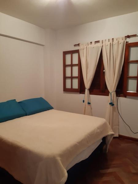 1 dormitorio con cama blanca y ventana en Departamento Centro en San Salvador de Jujuy