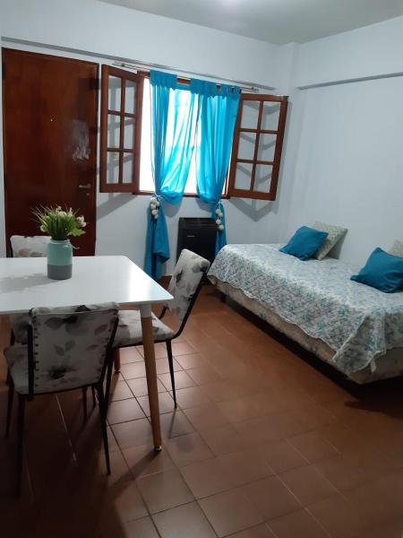Habitación con 2 camas, mesa y sillas en Departamento Centro en San Salvador de Jujuy