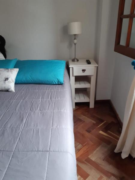 1 dormitorio con cama azul y mesita de noche en Departamento Centro en San Salvador de Jujuy