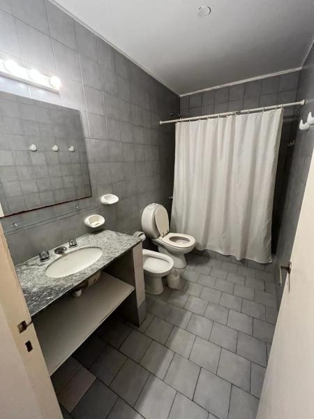 y baño con aseo, lavabo y espejo. en Casa Mar del Plata en Mar del Plata