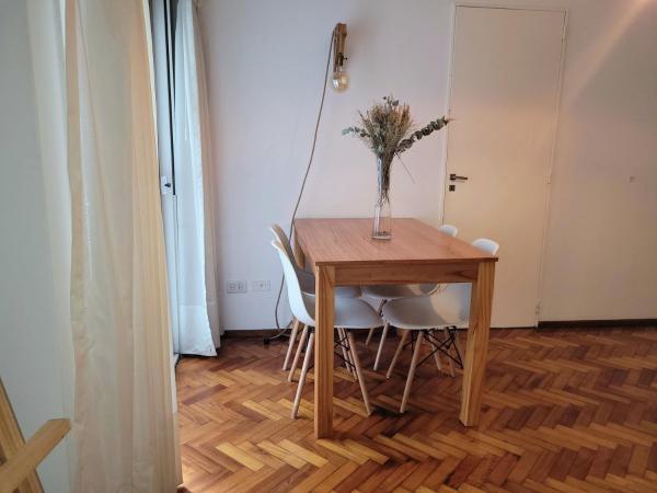 una mesa de comedor con sillas y un jarrón con flores en El lugar en Palermo Chico en Buenos Aires