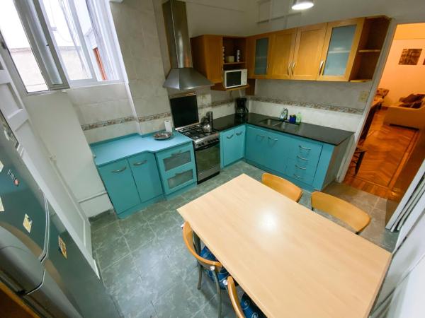 cocina con armarios azules y mesa de madera en Departamento Sarmiento en Buenos Aires