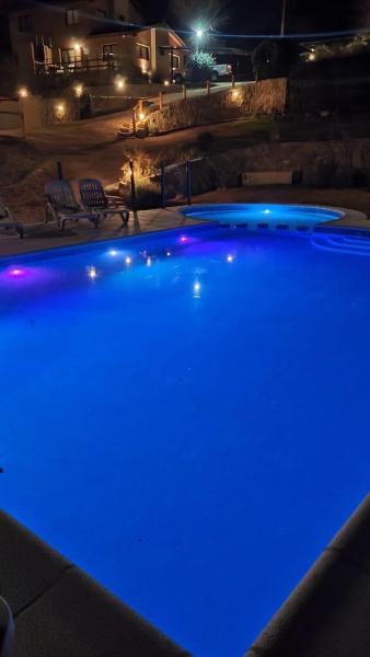 una piscina iluminada por la noche con luces azules en Cerro Negro, Complejo en Villa General Belgrano