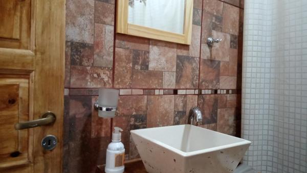 baño con lavabo y pared de azulejos en EN LO DE PEPE en San Juan