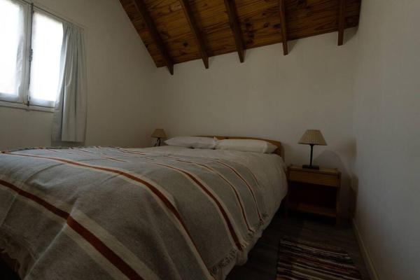 1 dormitorio con 1 cama grande y ventana en Casa 5 personas SMA en San Martín de los Andes