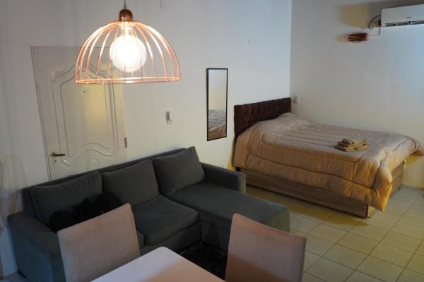 sala de estar con sofá y cama en Departamento en el centro (monoambiente completo) en Puerto Iguazú