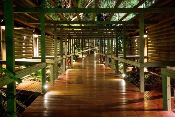 Una pasarela de madera con luces en un edificio en La Reserva Virgin Lodge en Puerto Iguazú