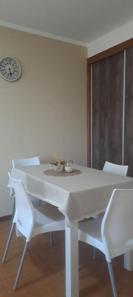 mesa de comedor blanca con sillas blancas y reloj en Encantador Departamento - Luminoso - a tan solo 4 cuadras de la Playa y de la mejor gastronomia de MDP en Mar del Plata