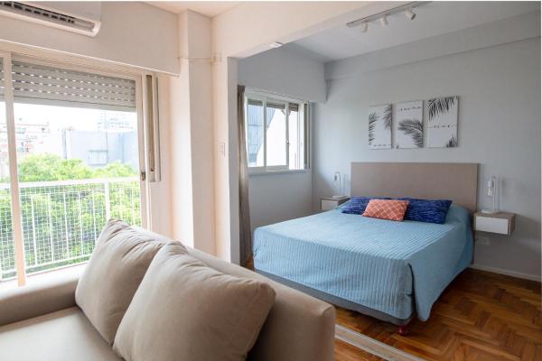 1 dormitorio con cama, sofá y ventana en AIRESSOHO 525A en Buenos Aires