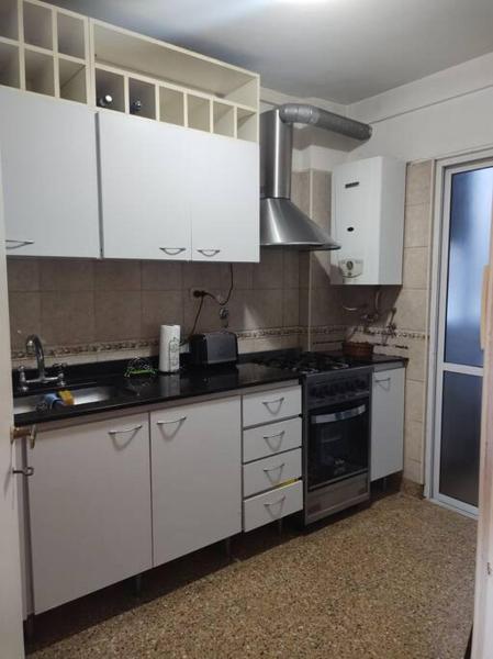 cocina con armarios blancos y fogones en Excelente depto 3 ambientes en Buenos Aires