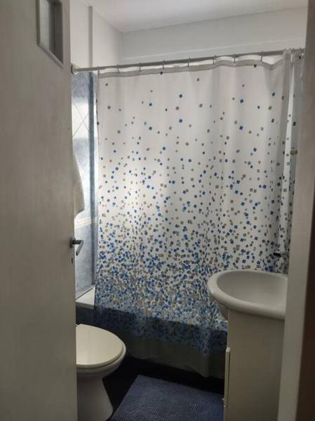 y baño con cortina de ducha y aseo. en Excelente depto 3 ambientes en Buenos Aires
