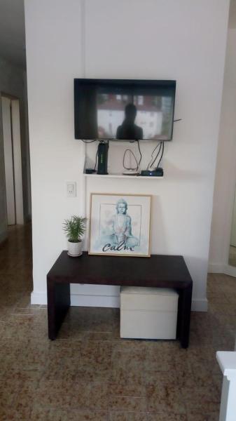 sala de estar con TV en la pared en DEPARTAMENTO PINAMAR CENTRO en Pinamar