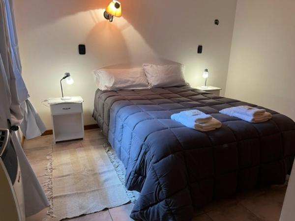 1 dormitorio con 1 cama con 2 toallas en San Martín de los Andes Depto para 4 Pax en San Martín de los Andes