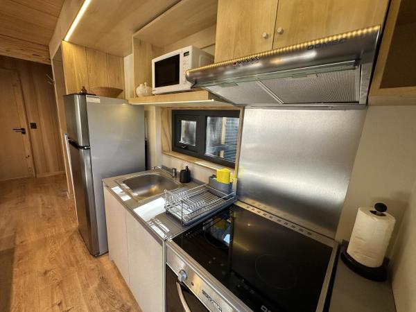 cocina con refrigerador de acero inoxidable y fregadero en Hermoso departamento de diseño, en el centro de SMA. 22V5 en San Martín de los Andes