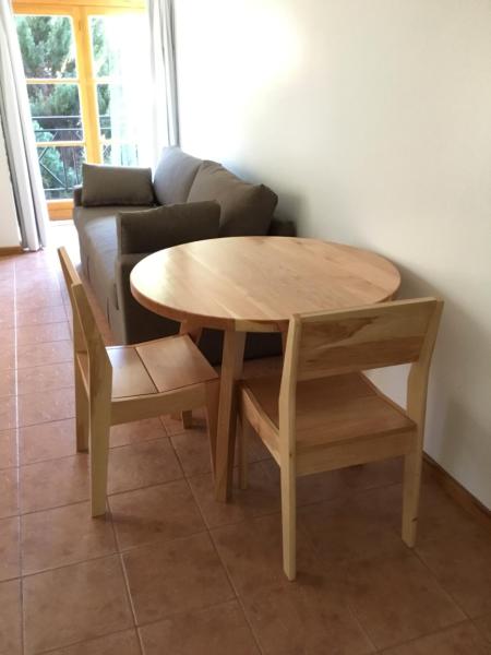 una mesa de madera y sillas en la sala de estar. en Departamento victoria en San Martín de los Andes